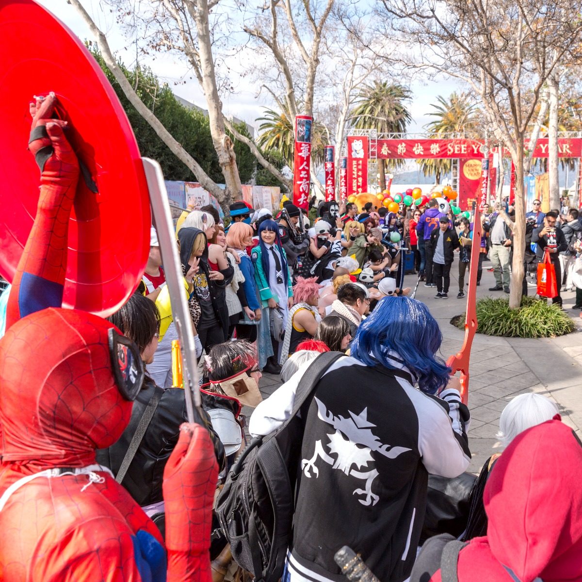 Cosplay fans gather beneath the festival entrance arch