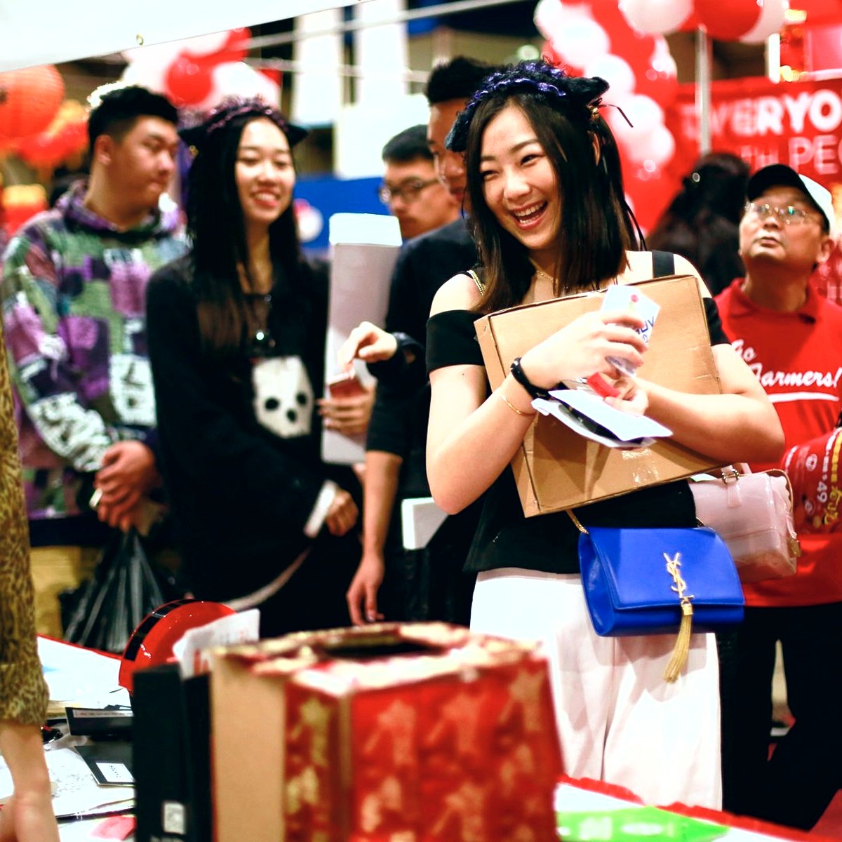 Attendees shopping and smiling at a vendor booth